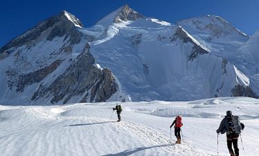 Climbers trekking during the Gasherbrum II Expedition with stunning views of the Karakoram mountains.