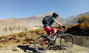 Cyclist riding through rugged terrain on a Taktok Brothers Mountain Bike Adventure.