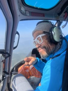 Passenger looking out of a helicopter window during a Taktok Brothers Heli Tour, admiring the scenic landscapes.